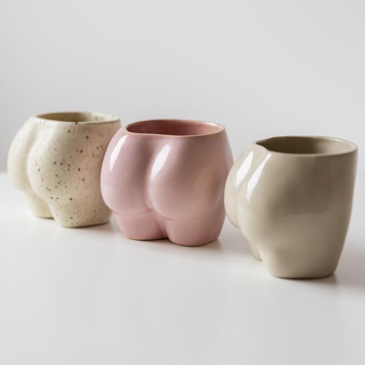 handgefertigte Body Becher aus Keramik in Natur, Rosa und Freckles von Studio Amun nebeneinander auf hellem Hintergrund