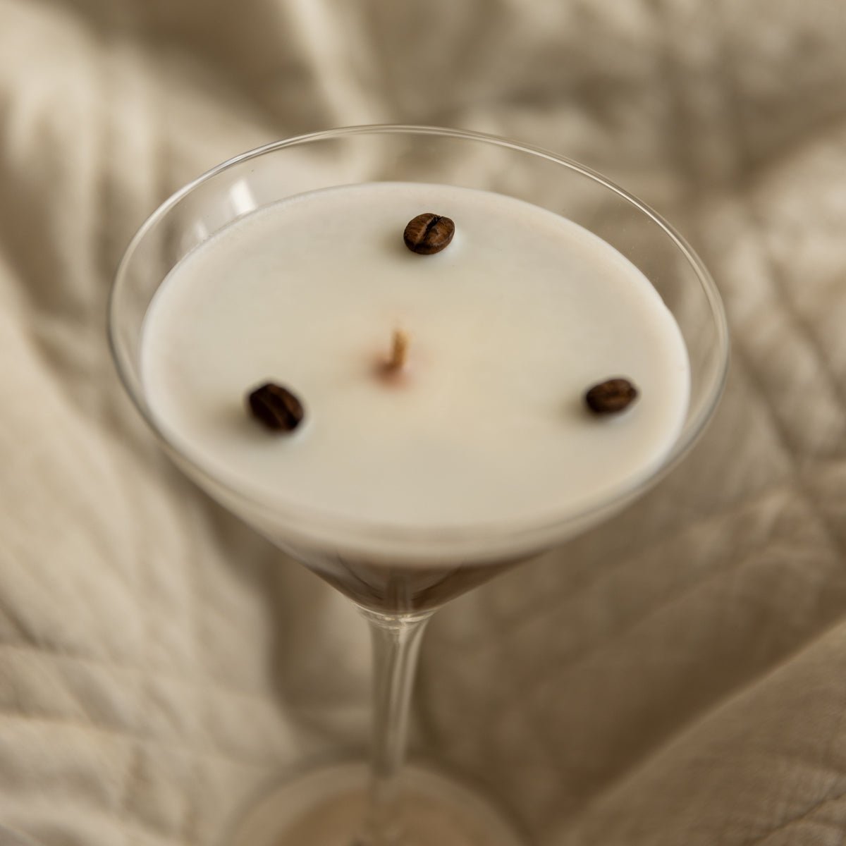 Detailansicht einer handgegossenen Duftkerze im Cocktailglas von Studio Amun mit sichtbaren Dochten