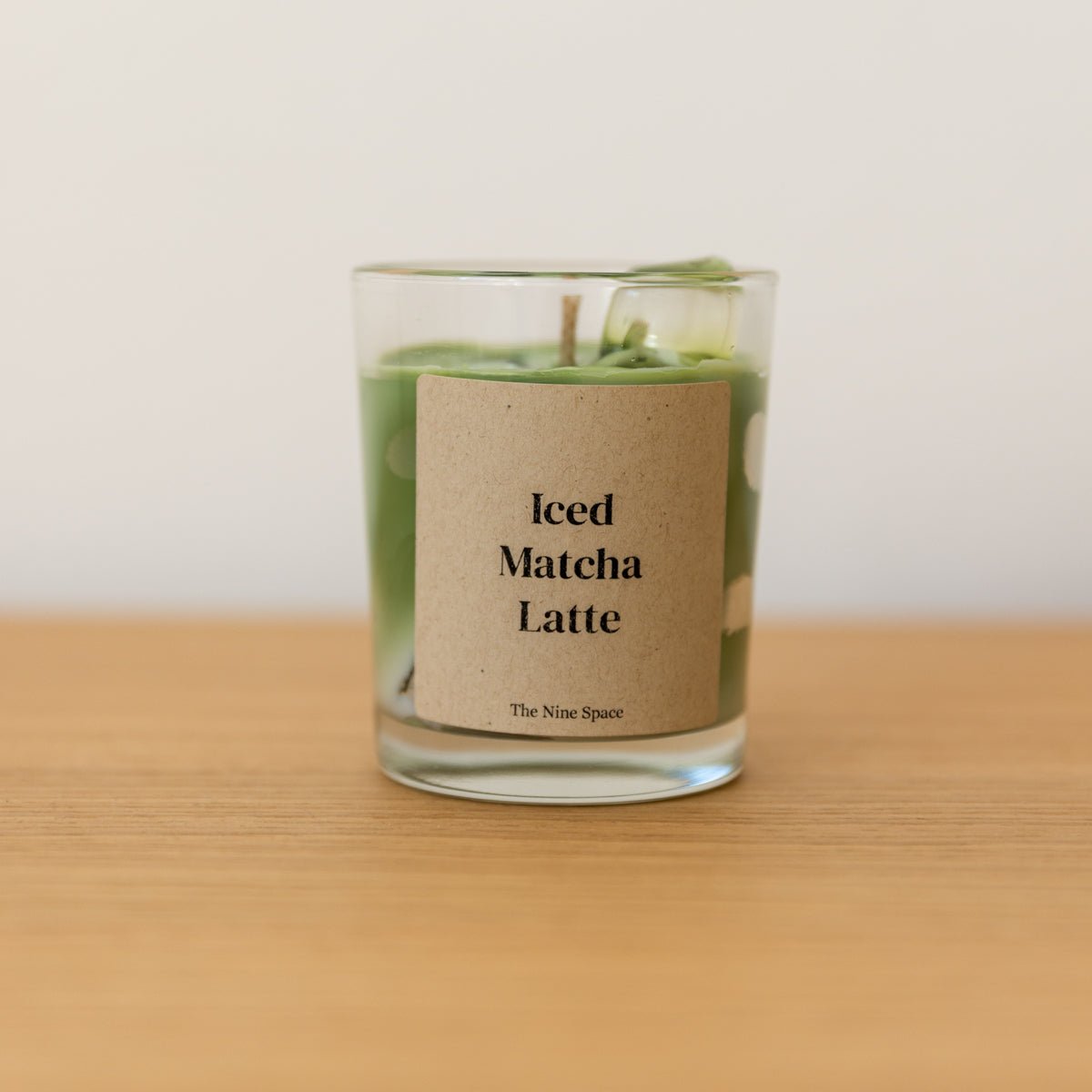handgegossene Duftkerze mit Matcha Duft Iced Matcha Latte im Glas von Studio Amun auf Holzoberfläche